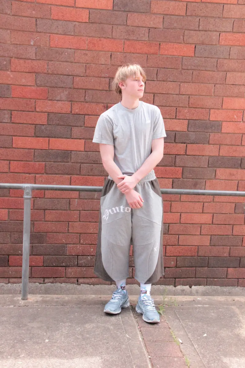 Model wearing VINTO grey jorts with a grey tee against a brick wall